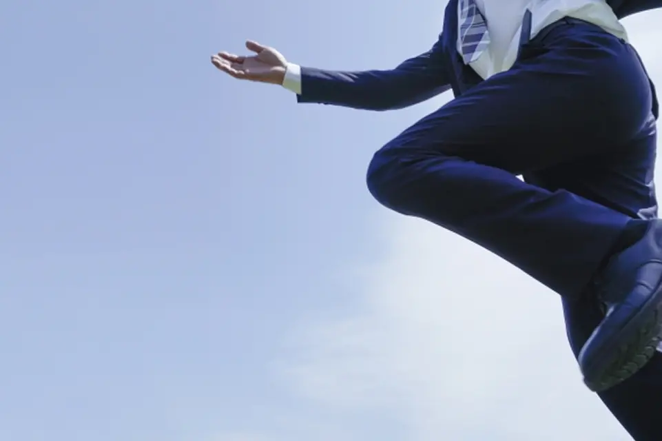 スーツを着た男性がジャンプをしている様子