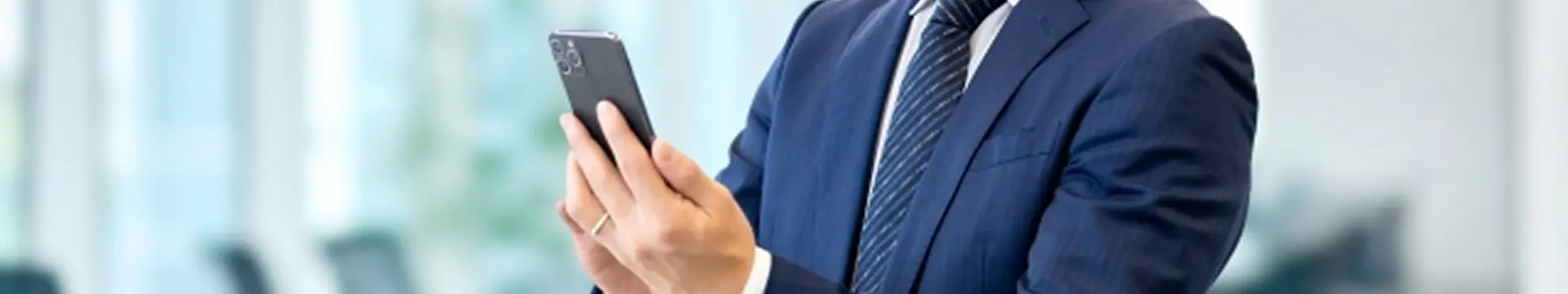 男性のサラリーマンがスマホを見ている様子